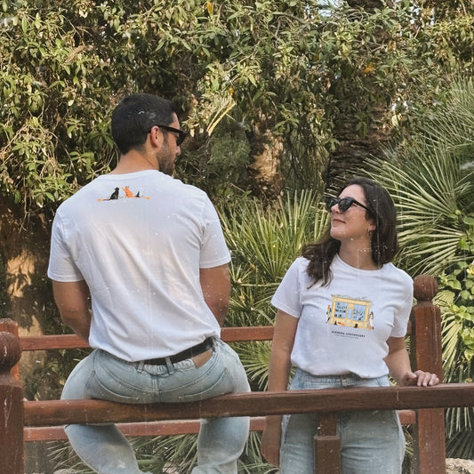 Camiseta blanca de Laniñabowie modelo magic season con ilustración fontal inspirada en "verbena apothecary", la tienda de las hermanas Owens de "Practical magic" e ilustración en el cuello con gatos mágicos. Modelo femenino y masculino.
