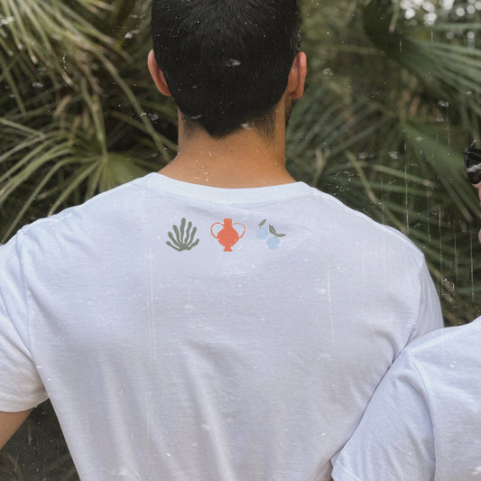 Espalda de la camiseta blanca de Laniñabowie modelo Plant lover con pequeños motivos de una planta, un jarrón naranja y una mariposa bajo el cuello