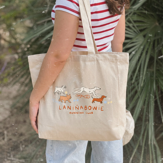 Bolso shopper de algodón con cremallera de Laniñabowie modelo "Running club" con ilustración inspirada en los clubes de running femenino pero en versión perruna con pug, french bulldog, galgo y teckel a la carrera. Frontal. 