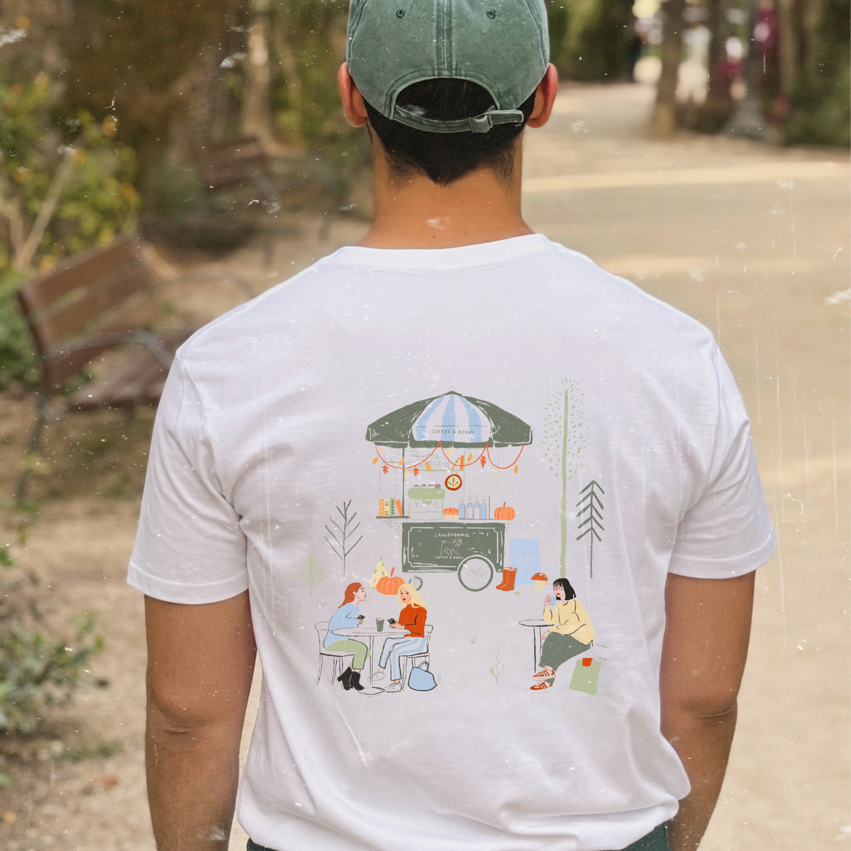camiseta blanca de Laniñabowie modelo Laniñabowie café con ilustración grande en la espalda inspirada en un café del parque con puesto de cafés y libros