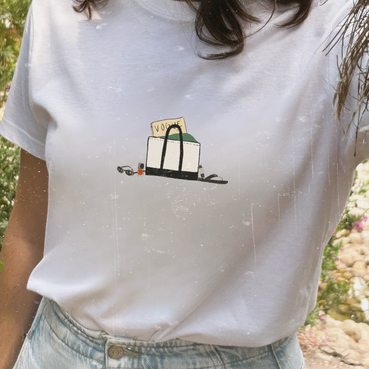 Camiseta de algodón orgánico de Laniñabowie modelo Carolyn en color blanco, con ilustración pequeña en el pecho con detalles como la revista vogue  con referencia a Carolyn Bessette-Kennedy.