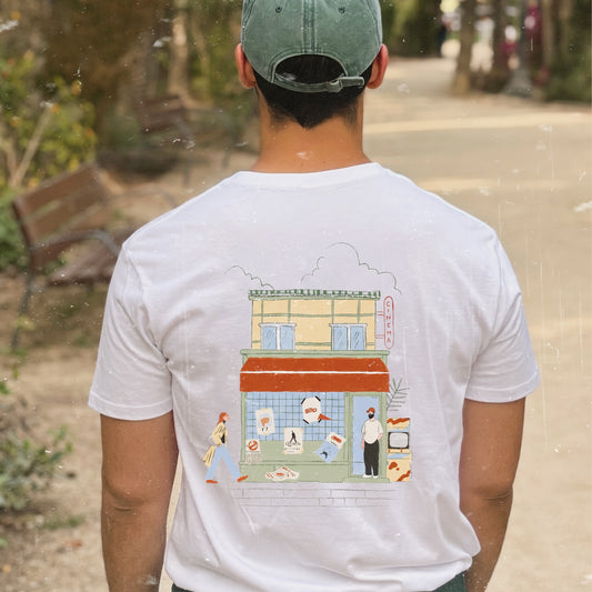 Camiseta de Laniñabowie modelo Retro feeling vista de espalda, con ilustración de una fachada de cine vintage con carteles de pelis icónicas como ET o tiburón y modelo femenino y masculino con ropa aire 80s. 