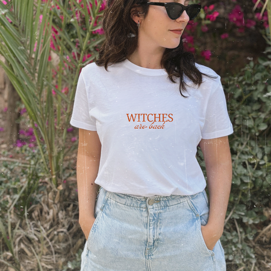 camiseta blanca de Laniñabowie modelo witches are back con ilustración en la parte frontal en rojo la frase "witches are back" inspirada en las famosas hermanas Sanderson de la película Hocus Pocus 