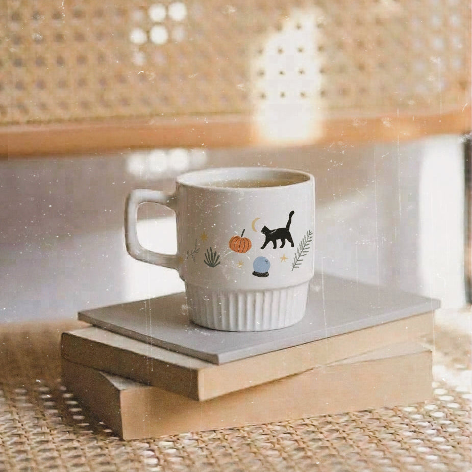 Taza de cerámica de color blanco de Laniñabowie modelo "Witches are back" con estampación hecho a mano en nuestro taller inspirada en el universo de Hocus Pocus con frase en rojo "witches are back" y elementos como el gato Binx. Lateral. 
